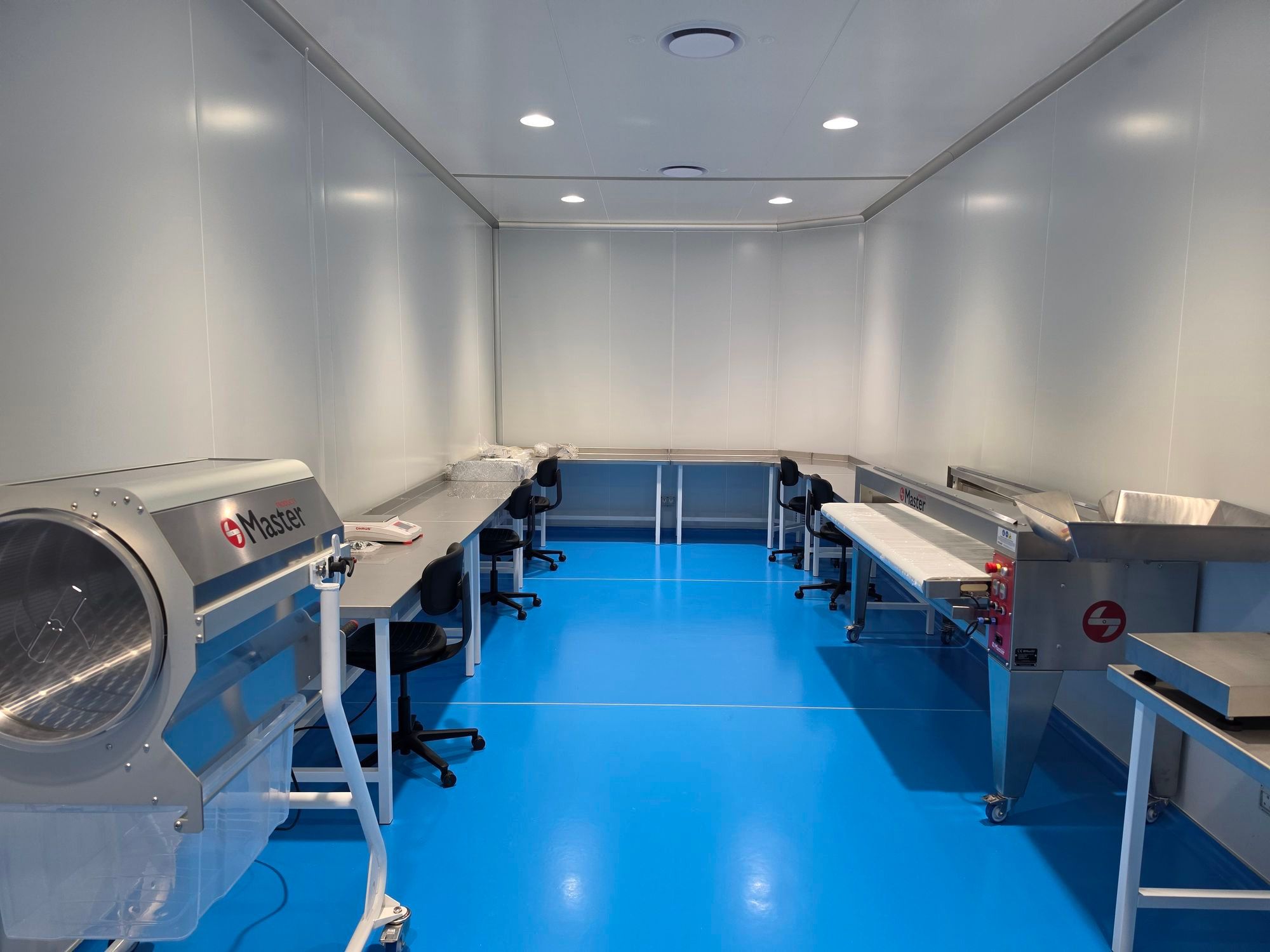 Processing room with stainless-steel workbenches, chairs and processing equipment